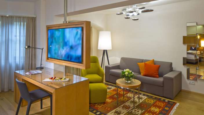 Ein Wohnzimmer mit einem Fernseher und einem Schreibtisch