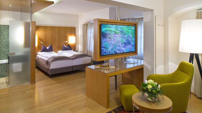 Ein Hotelzimmer mit einem Fernseher und einem Stuhl