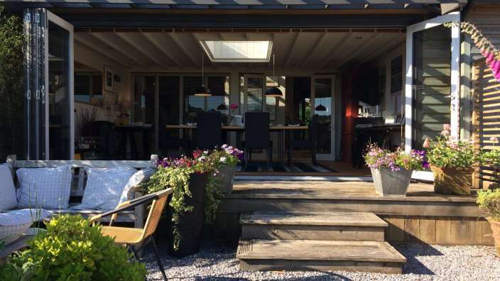 Ein Haus mit einem Tisch und Stühlen davor