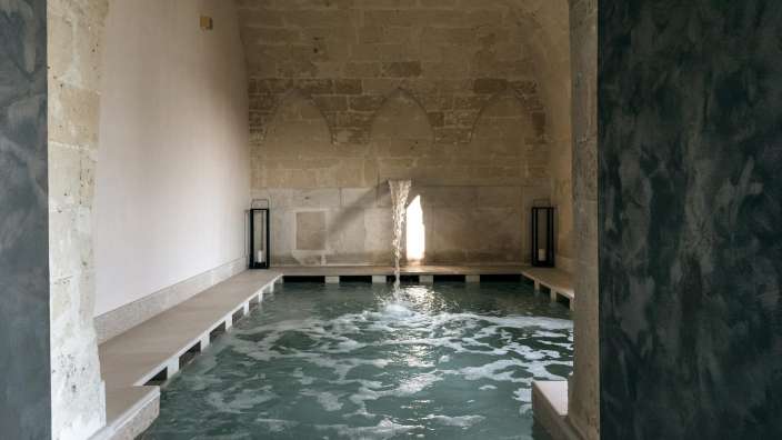 Ein kleiner Pool in einem Raum mit Steinwänden