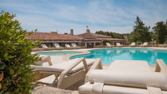 Ein großer Pool mit Liegestühlen und Stühlen um ihn