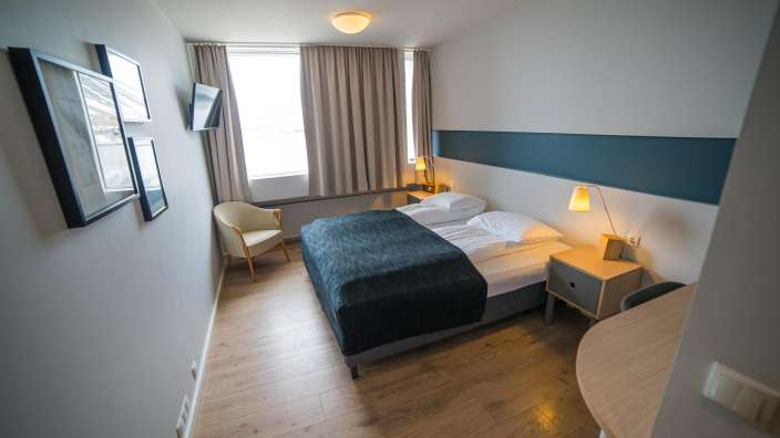 Ein Hotelzimmer mit einem Bett und einem Stuhl