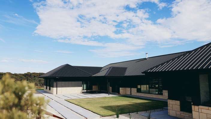 Ein großes schwarzes Haus mit einem blauen Himmel dahinter