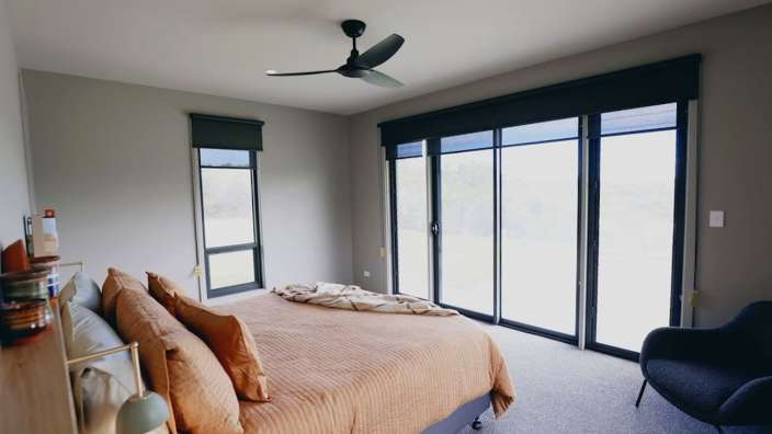 Ein Schlafzimmer mit einem Bett und einem Deckenventilator