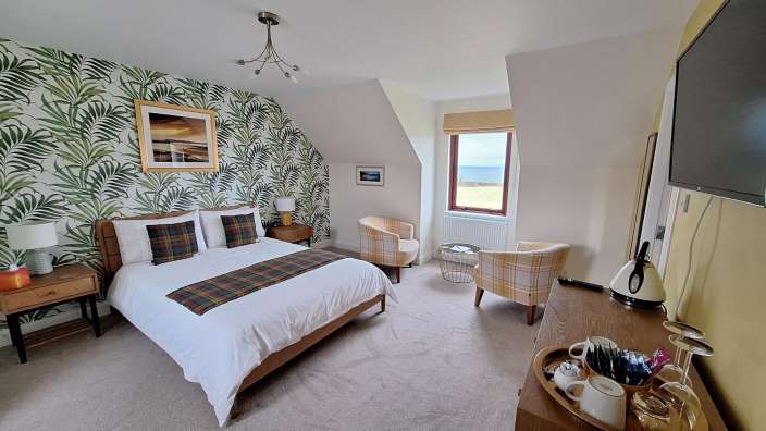 Ein Schlafzimmer mit einem Bett und zwei Stühlen