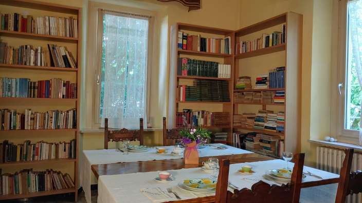 Ein Tisch und Stühle in einem Raum mit Bücherregalen