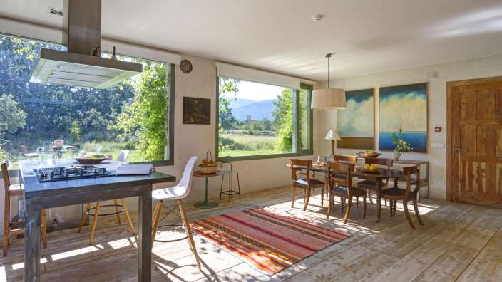 Ein Esszimmer mit einem Tisch und Stühlen und einem großen Fenster