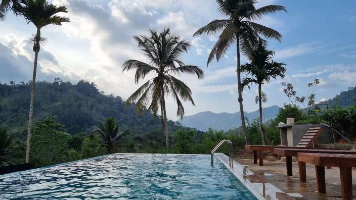 Ein Pool mit Palmen und Bergen im Hintergrund