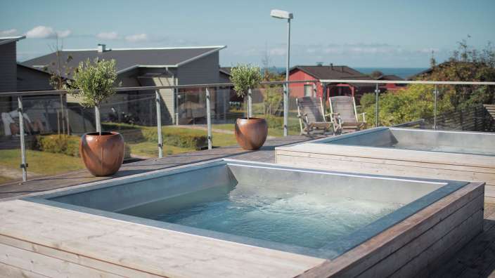 Zwei Whirlpools auf einem Holzdeck mit Blick auf das Meer