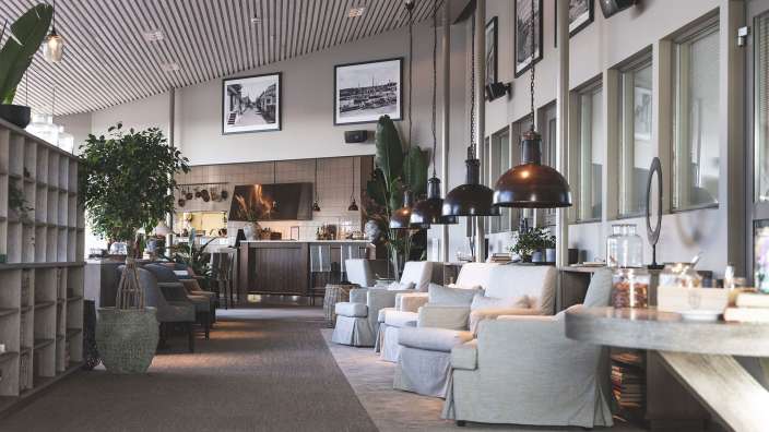 Ein Wohnzimmer mit vielen Möbeln und Bildern an der Wand