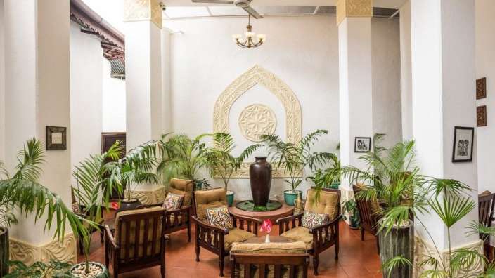 Ein Wohnzimmer mit vielen Möbeln und Pflanzen