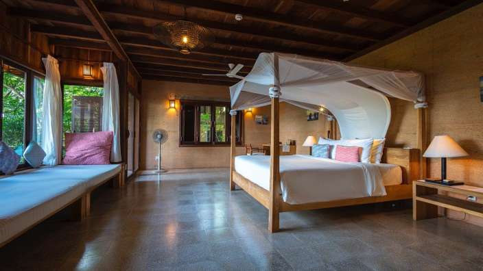 Ein Schlafzimmer mit einem Himmelbett und einem Ventilator