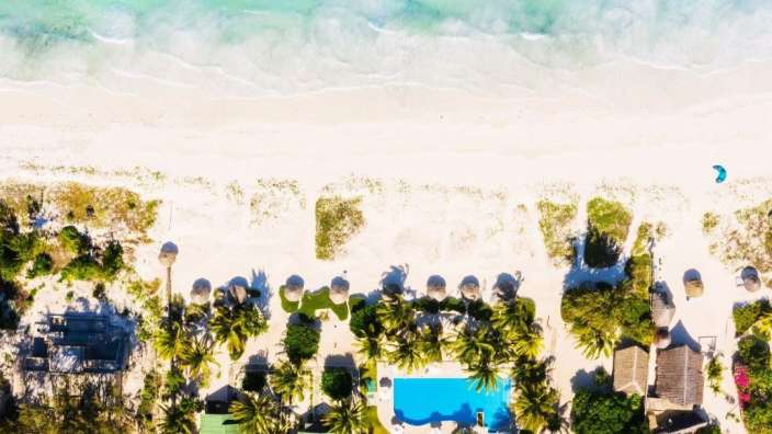Eine Luftaufnahme eines tropischen Strandes mit einem großen Pool
