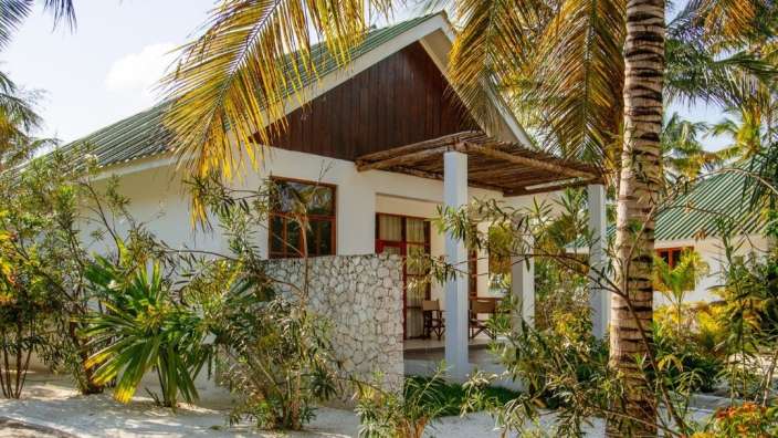 Ein kleines weißes Haus mit einem grünen Dach