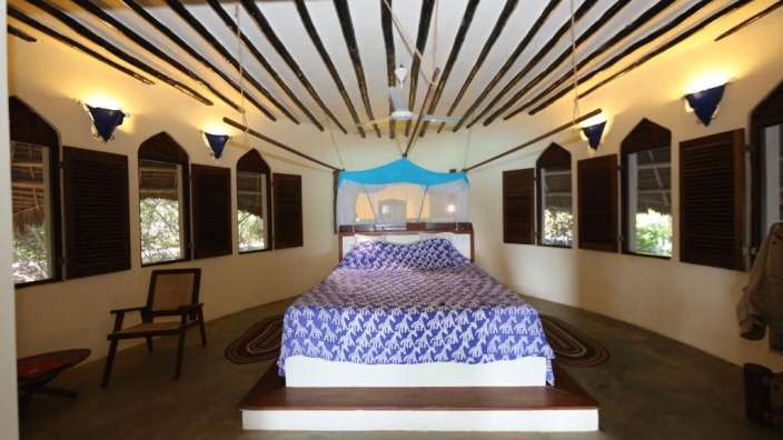 Ein Schlafzimmer mit einem Bett und vielen Fenstern