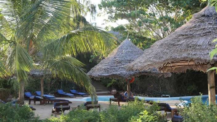 Eine Gruppe von Strohhütten neben einem Pool