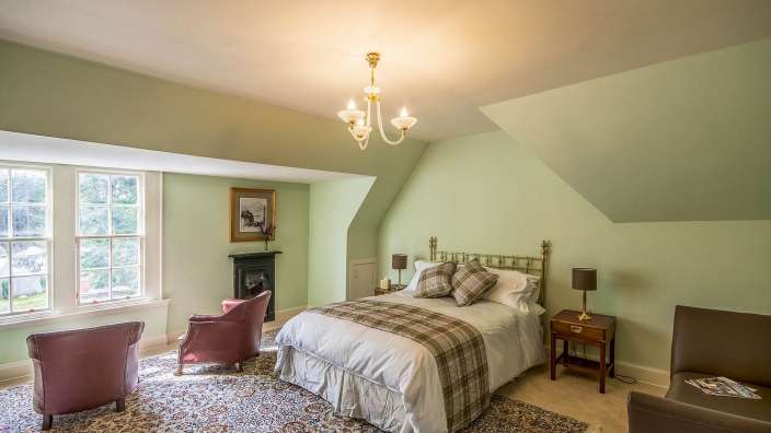 Ein Schlafzimmer mit einem Bett und zwei Stühlen