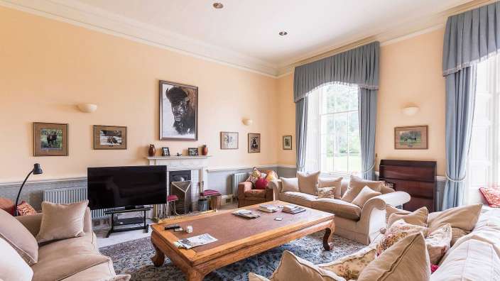 Ein Wohnzimmer mit vielen Möbeln und einem Fernseher