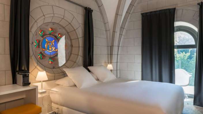 Ein Schlafzimmer mit einem Bett und einem Buntglasfenster
