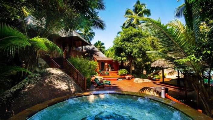 Ein Whirlpool in einem tropischen Garten neben einem Haus