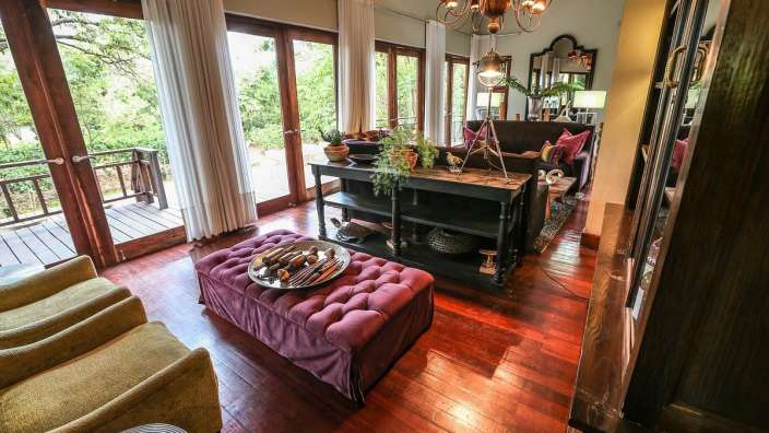 Ein Wohnzimmer mit vielen Fenstern und einem lila Hocker