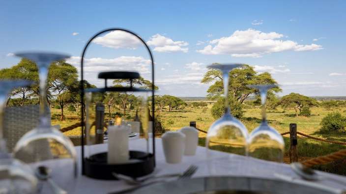 Ein Tisch mit Kerzen und Weingläsern mit einer Landschaft im Hintergrund