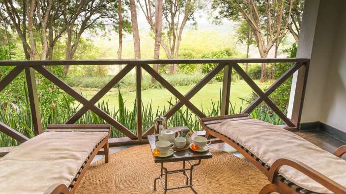 Ein Tisch mit Tassen und einer Teekanne auf einem Balkon