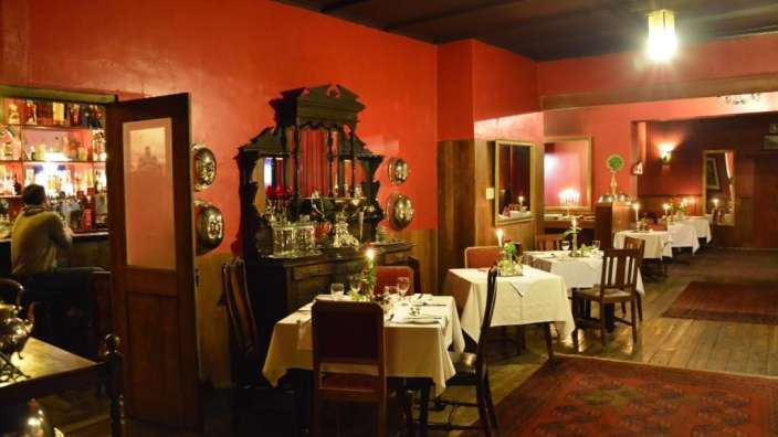 Ein Restaurant mit roten Wänden und Tischen und Stühlen