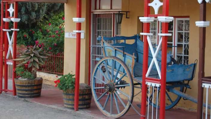 Ein blauer Wagen steht vor einem roten und weißen Gebäude