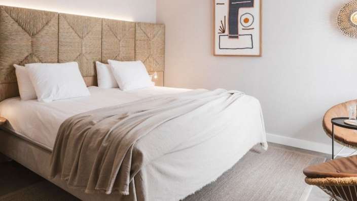 Ein Schlafzimmer mit einem Bett und einem Gemälde an der Wand