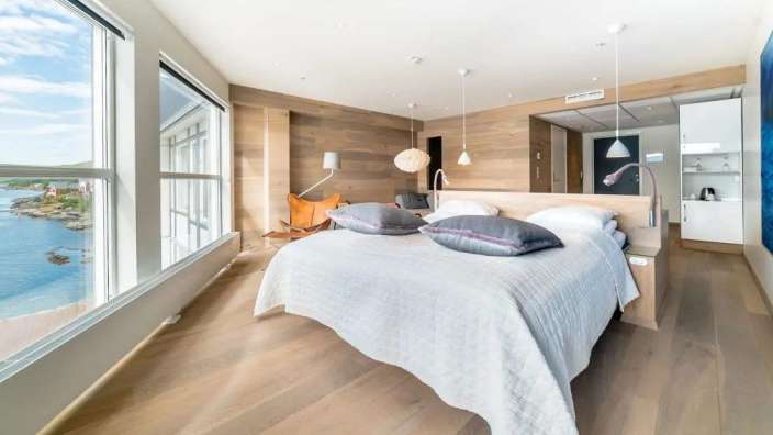 Ein Hotelzimmer mit einem großen Bett und vielen Fenstern