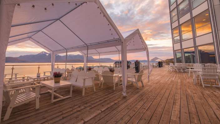 Eine Terrasse mit weißen Möbeln und weißen Zelten