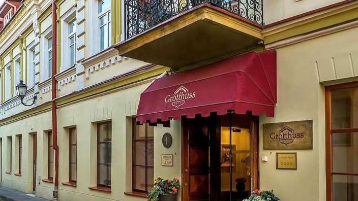 Ein Gebäude mit einem roten Vorhang und einem Schild, das sagt grotthuss hotel