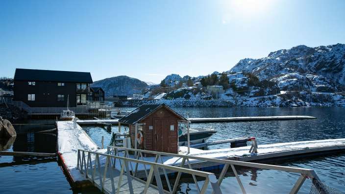 Ein Dock mit einer kleinen Hütte darauf und einem Boot dahinter
