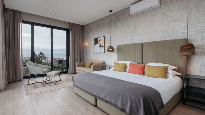 Ein Hotelzimmer mit einem großen Bett und einem Stuhl