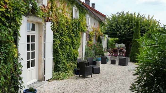 Ein Haus mit einem Tisch und Stühlen davor