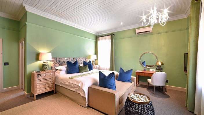 Ein Schlafzimmer mit grünen Wänden und einem großen Bett