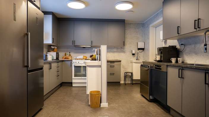 Eine Küche mit vielen Geräten und grauen Schränken