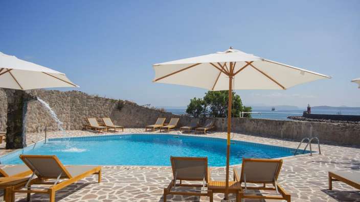 Ein Pool mit Liegestühlen und Sonnenschirmen um ihn