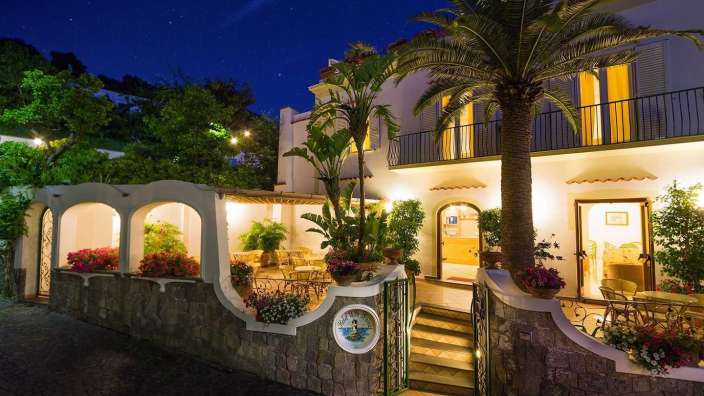 Ein weißes Haus mit einer Palme davor