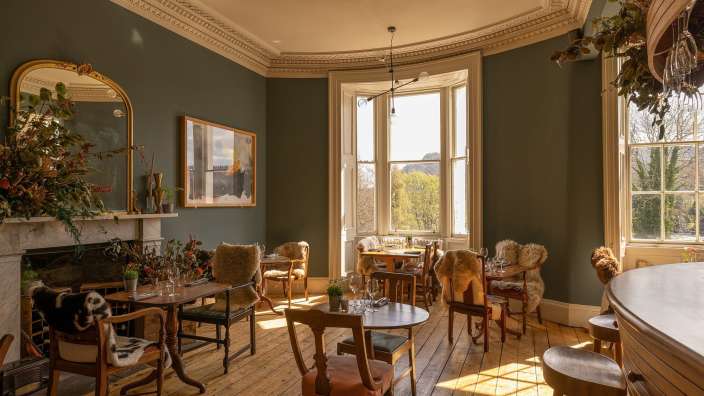 Ein Wohnzimmer mit vielen Stühlen und Tischen