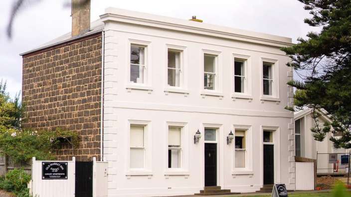 Ein großes weißes haus mit einem schild davor