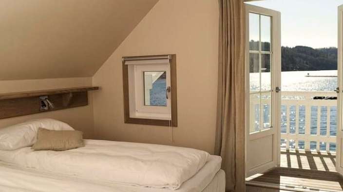 Ein Schlafzimmer mit zwei Betten und einem Fenster mit Blick auf einen See