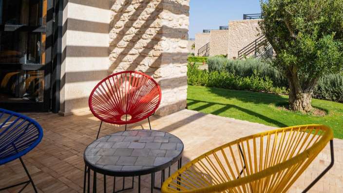 Eine Terrasse mit bunten Stühlen und einem Tisch