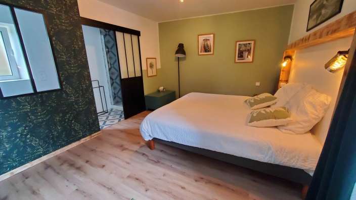 Ein Schlafzimmer mit einem Bett und einer grünen Wand
