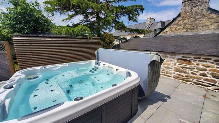Ein Whirlpool auf einer Terrasse mit einem Baum im Hintergrund