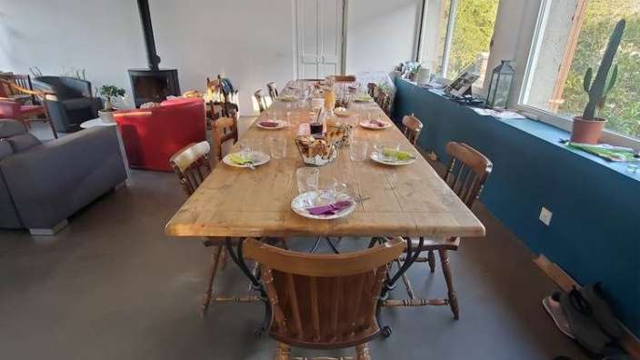 Ein langer Holztisch mit Tellern und Gläsern darauf
