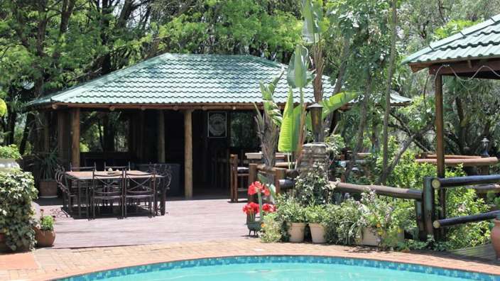 Ein schwimmbad mit einem tisch und stühlen davor