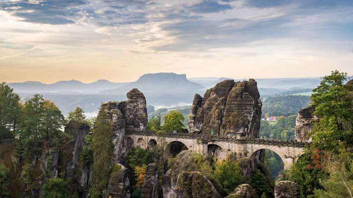 Eine Brücke über einen Fluss mit einem Berg im Hintergrund