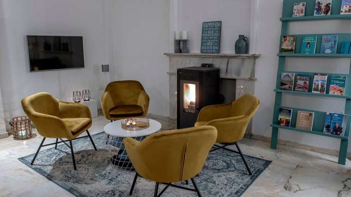 Ein Wohnzimmer mit gelben Stühlen und einem Holzofen